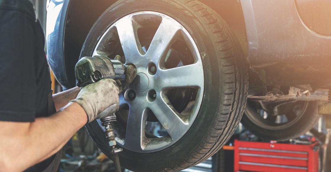 mechanic screwing in a tire